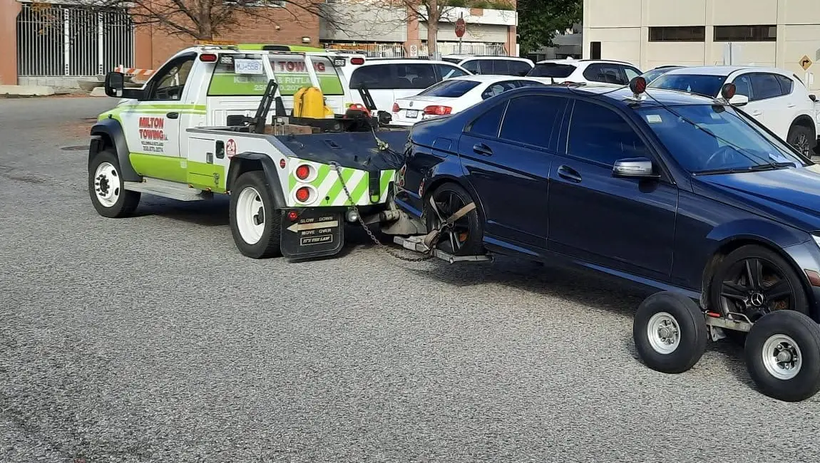 Milton Towing’s branded wrecker loading a car